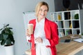attractive businesswoman standing with coffee in paper cup