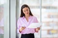 Attractive businesswoman standing at the glass office and text messaging Royalty Free Stock Photo