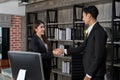 attractive businesswoman standing and shaking hand with businessman partner with smile in office room. satisficed collaboration Royalty Free Stock Photo