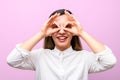 Attractive businesswoman or student with red lips in white shirt smiling and making glasses from her fingers against Royalty Free Stock Photo