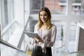 Attractive businesswoman using a digital tablet while standing on the stairs in the office Royalty Free Stock Photo