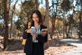 Attractive businesswoman using smartphone while walking in an autumn park Royalty Free Stock Photo