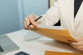 Attractive businesswoman in white suit hand open business report from document envelope and working on desk in meeting room Royalty Free Stock Photo