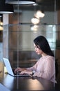 Attractive businesswoman working with laptop computer while sitting in modern office. Royalty Free Stock Photo