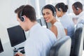 Attractive call centre employee looking over shoulder Royalty Free Stock Photo