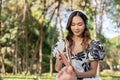 Attractive Asian woman is listening to music on her headphones and reading a book while picnicking Royalty Free Stock Photo