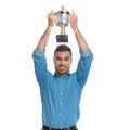 Attractive casual man holding his trophy overhead