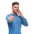 Attractive casual man speaking on the phone makes ok sign Royalty Free Stock Photo