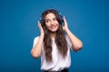 Attractive caucasian or arab brunette girl in a white t-shirt listening to her favorite music on headphones and smiling  o Royalty Free Stock Photo