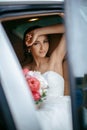 Attractive caucasian bride sitting in car and smile to the camera Royalty Free Stock Photo