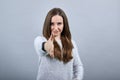 Attractive caucasian brunette woman in sweater spread hand for greeting