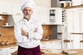 Attractive Caucasian chef standing with arms crossed in a restaurant kitchen