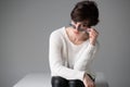 Attractive caucasian girl with shot dark hair with sunglasses looking at camera over gray background. Young beautiful woman posing Royalty Free Stock Photo