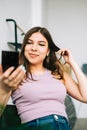 Attractive caucasian young woman holding cosmetic mirror in hand and looking on herself Royalty Free Stock Photo