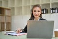 Attractive Asian businesswoman working in her office, using laptop computer, focusing on her tasks Royalty Free Stock Photo