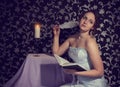 Attractive charming romantic girl with beautiful body reading a book and writing a poem and verses Royalty Free Stock Photo