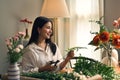 An Asian woman arranging beautiful fresh flowers in her living room Royalty Free Stock Photo