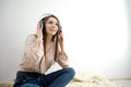 European American woman pink blouse with headphones Attractive cheerful woman listening and enjoying music in headphones Royalty Free Stock Photo