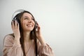 European American woman pink blouse with headphones Attractive cheerful woman listening and enjoying music in headphones Royalty Free Stock Photo