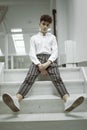 Attractive cheerful handsome young male model poses down on the stairs. Black and white image. Royalty Free Stock Photo