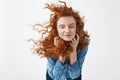 Attractive cheerful redhead girl with flying curly hair smiling laughing with closed eyes over white background. Royalty Free Stock Photo