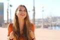 Attractive cheerful traveler woman visiting seaside town. Tourist girl exploring city with backpack Royalty Free Stock Photo