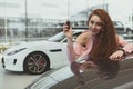 Happy woman holding car keys to her new automobile Royalty Free Stock Photo