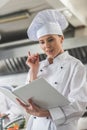attractive chef reading recipe and showing idea gesture