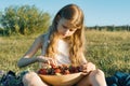 Attractive child girl eating strawberry. Nature background, green meadow, country style Royalty Free Stock Photo