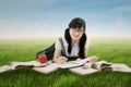 Attractive Chinese schoolgirl learns at field Royalty Free Stock Photo