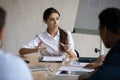 Attractive coach leader businesswoman talking and conducts training in boardroom.