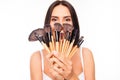 Attractive comic girl hiding behind makeup brushes