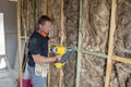 Attractive and confident constructor carpenter or builder man working wood with electric drill at industrial construction site Royalty Free Stock Photo