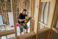 Attractive and confident constructor carpenter or builder man working wood with electric drill at industrial construction site Royalty Free Stock Photo