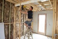 Attractive and confident constructor carpenter or builder man working wood with electric drill at industrial construction site Royalty Free Stock Photo