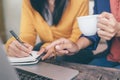 Attractive confident two business women in hand coffee cup drinking in smart working on laptop creative in her work station. and w Royalty Free Stock Photo