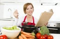 Attractive cook woman preparing vegetable stew soup reading recipe cookbook at domestic kitchen