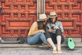 Attractive and cool women lesbian couple looking mobile phone and smiling each other in a red door background. Same sex happiness Royalty Free Stock Photo