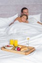 Attractive couple asleep with breakfast tray on bed Royalty Free Stock Photo