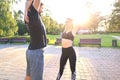 Attractive couple doing stretch together and smiling while working out in park outdoors Royalty Free Stock Photo