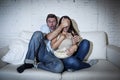 Attractive couple having fun at home enjoying watching television horror movie show Royalty Free Stock Photo