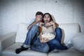 Attractive couple having fun at home enjoying watching television horror movie show Royalty Free Stock Photo