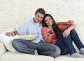 Attractive couple having fun at home enjoying watching television horror movie show Royalty Free Stock Photo