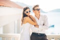 Attractive couple looking at amazing sea view.Enjoying sun and sunny weather and breathing in fresh ocean air.Enjoying moment