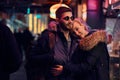 Attractive couple in love. A beautiful girl hugging her boyfriend standing in the night on the street. Royalty Free Stock Photo