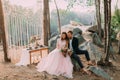 Attractive couple newlyweds, happy and joyful moment. Man and woman in festive clothes sit on the stones near the