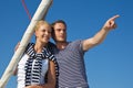 Attractive couple on sailing boat: man pointing with forefinger