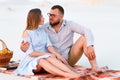 Attractive couple sitting together on the white sand beach, look Royalty Free Stock Photo