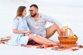 Attractive couple sitting together on the white sand beach, look Royalty Free Stock Photo