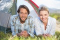 Attractive couple smiling at camera from inside their tent Royalty Free Stock Photo